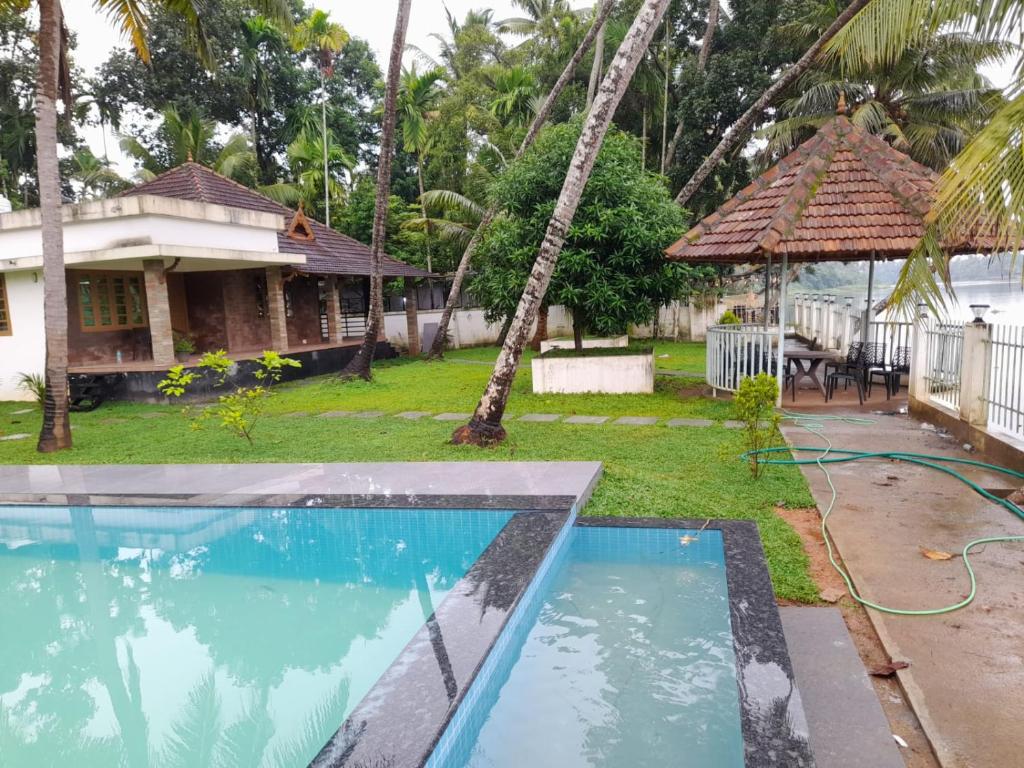 a house with a swimming pool in the yard at RiverSoul Pool Villa in North Paravur
