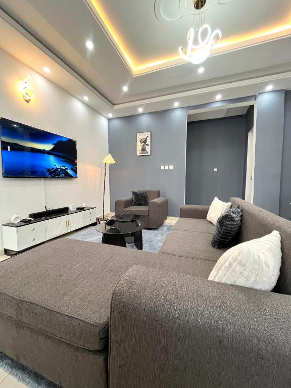 a living room with a large bed and a couch at Western Suites in Douala