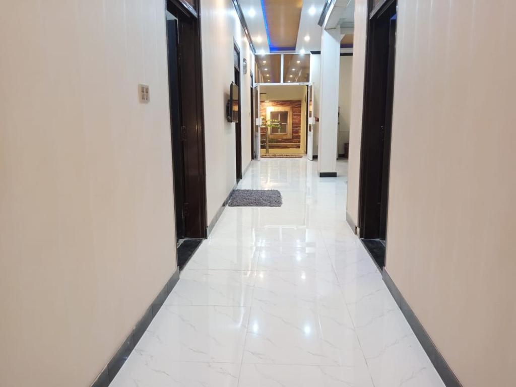 a hallway of a building with white floors and doors at Asghar Ali Resort in Lower Topa