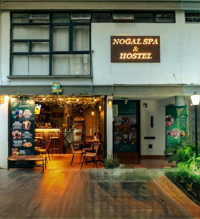 a restaurant with tables and chairs outside of a building at NOGAL SPA & HOSTEl in Pereira