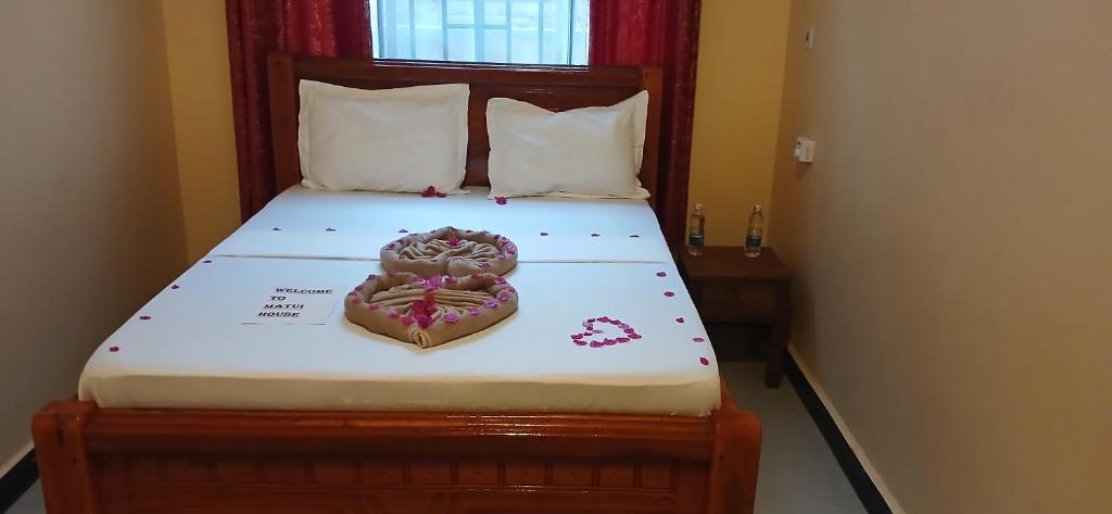 a bed with a heart made out of candy at Matui House in Kinyasini
