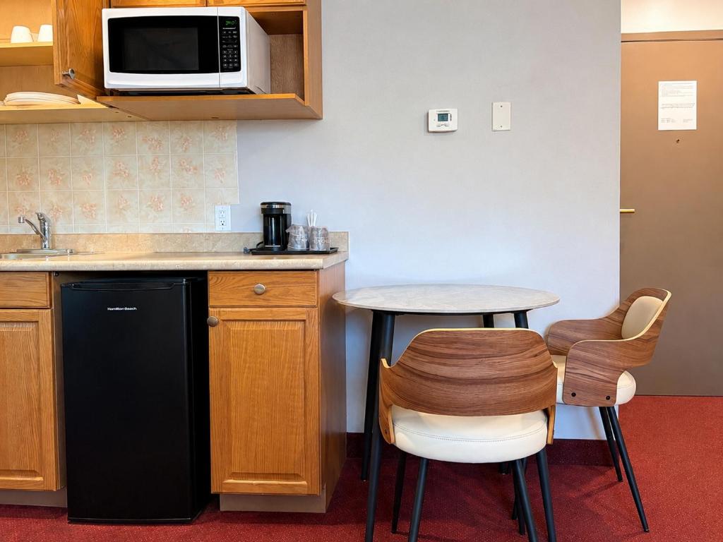 a kitchen with a small table and a microwave at Quality Inn & Suites in Vernon