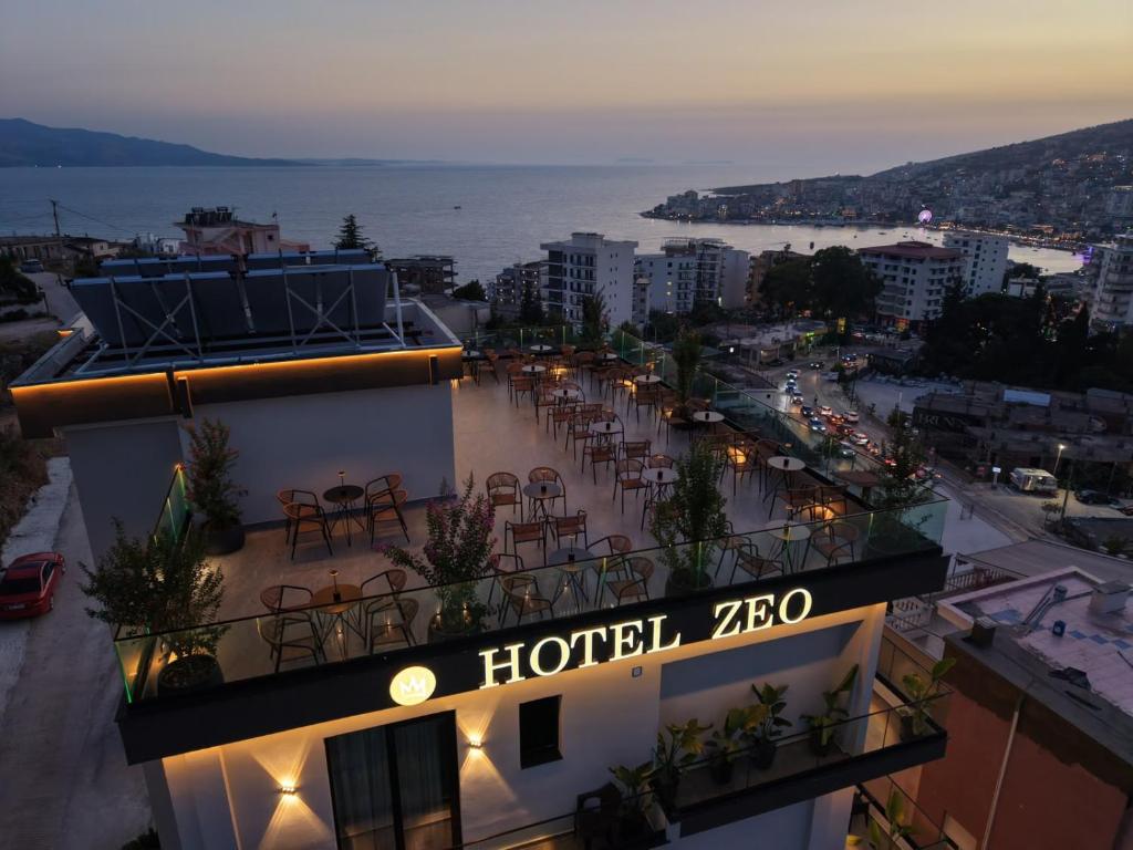 a hotel zebra with tables and chairs on a building at Zeo Hotel Saranda in Sarandë