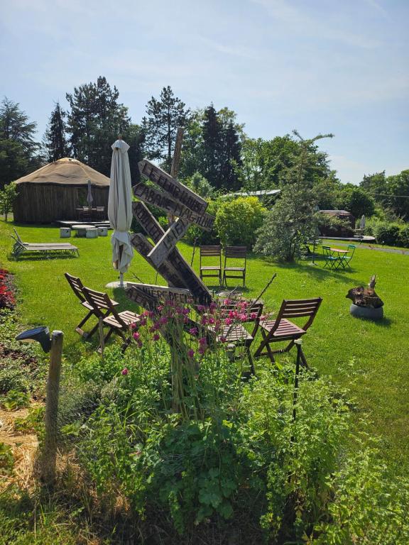 a garden with a table and an umbrella and chairs at les Refuges du Chalet in Sart-lez-Spa