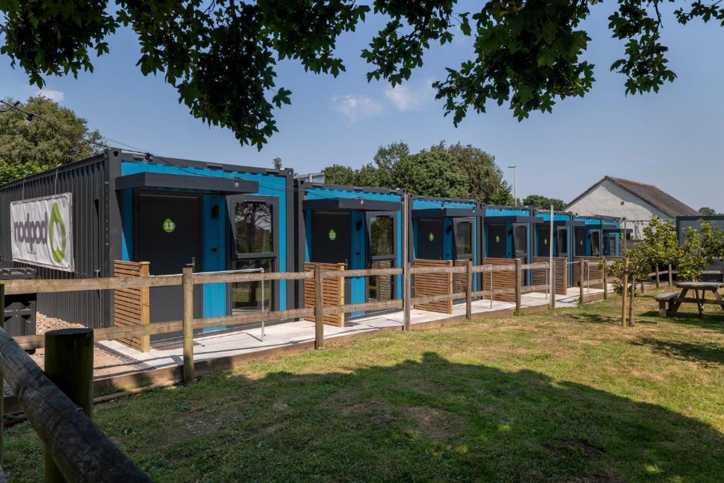 a row of blue portable toilets in a park at Nodpod Hotel in Bristol