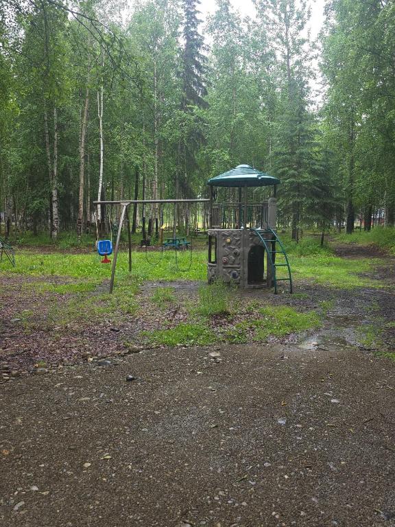 a playground in a park with a swing set at Houston Grass Station Campsite #41 in Wasilla