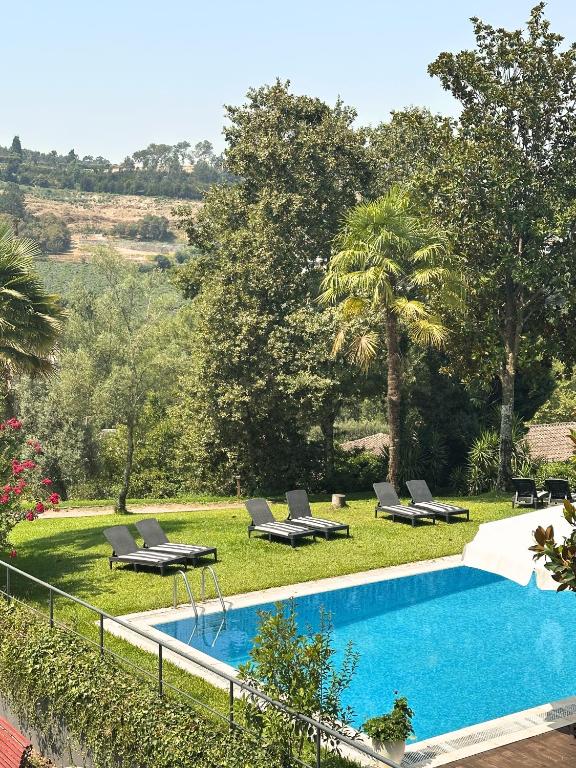 a swimming pool with lounge chairs next to a resort at Quinta do Mosteiro in Felgueiras
