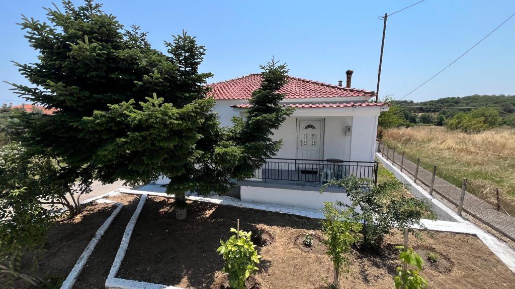 a white house with a tree in front of it at Avdera Holidays apartments in Ávdhira