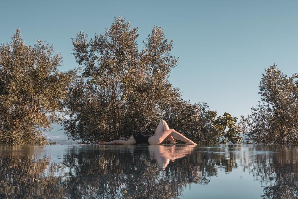 a woman laying on her back in the water at Puro Dão Hotel & Spa in Nelas