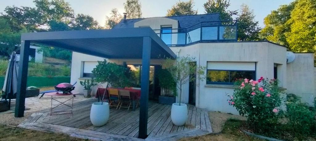 a house with a gazebo on a wooden deck at Pavillon des Chouettes in Brech