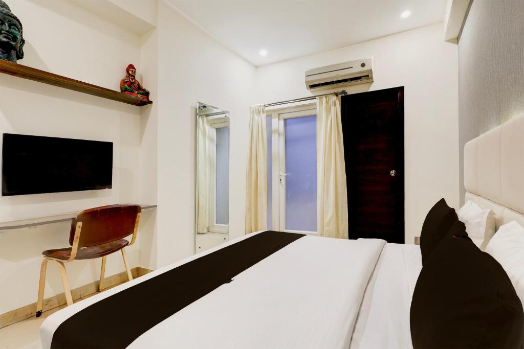 a bedroom with a bed and a chair and a television at Townhouse Hotel Sec- 54 Golf Course Road in Gurgaon
