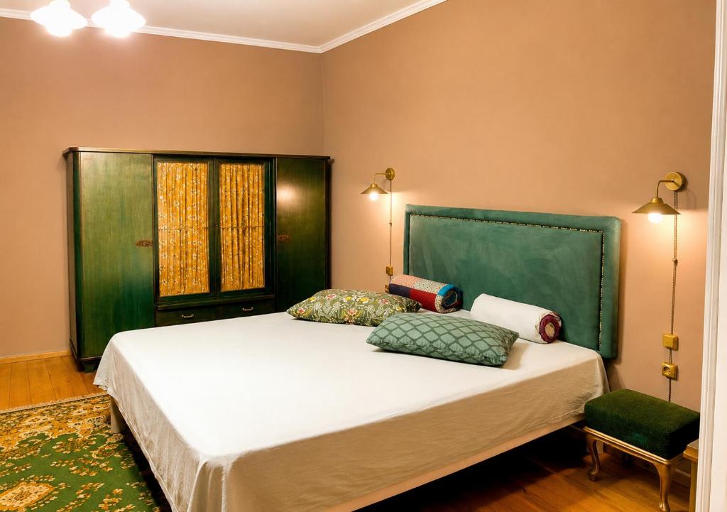 a bedroom with a bed with a green headboard at Vintage 4BR Borjomi Hideaway in Borjomi