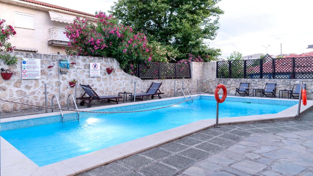 a swimming pool with blue water in front of a building at Oscar in Kallithea Halkidikis