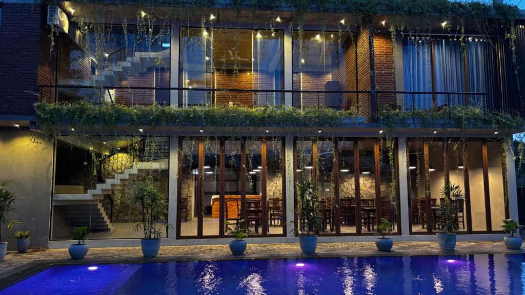 a building with a pool in front of it at night at Paris Garden Resort in Trincomalee