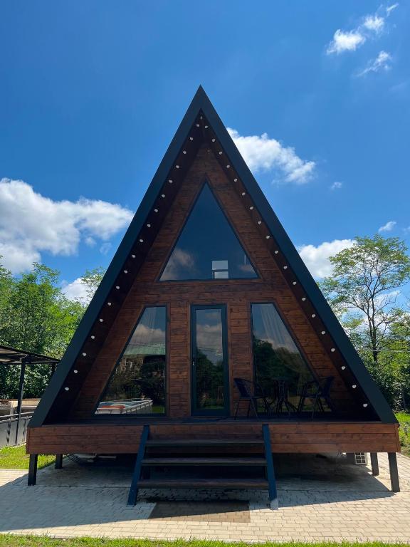 a triangular house with a bench in front of it at Aba Ula in Martvili