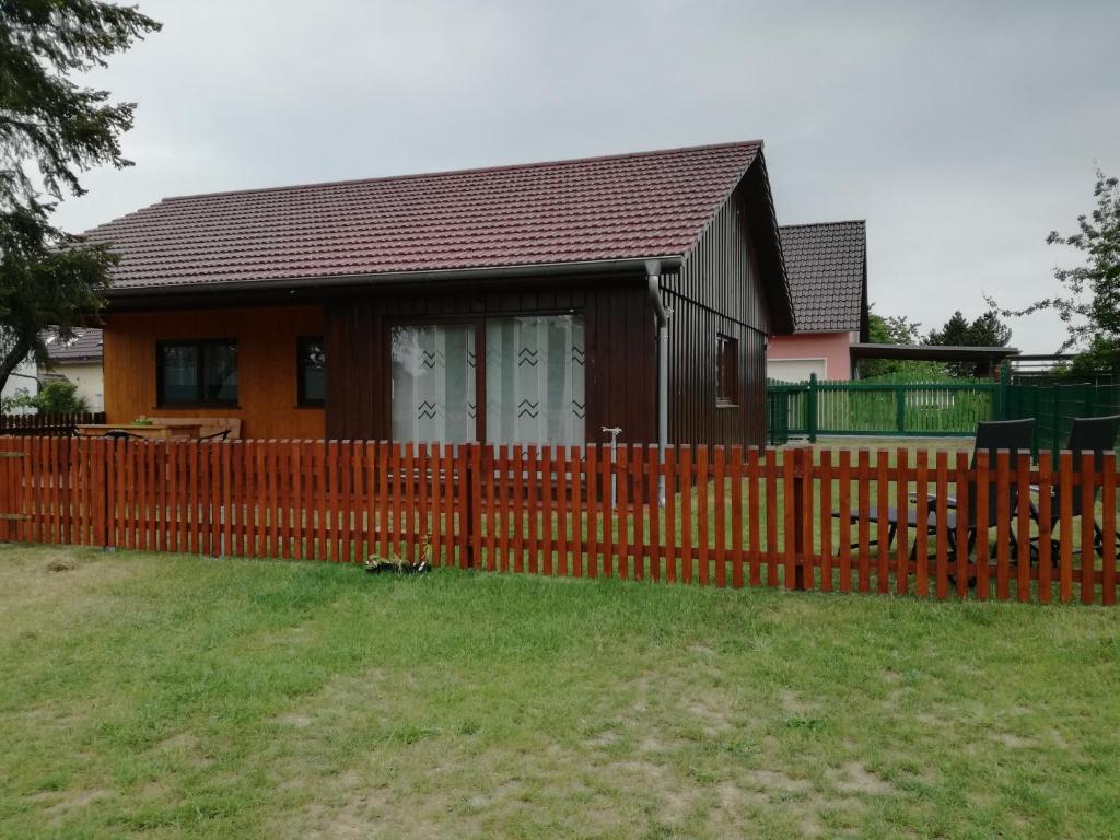 a wooden fence in front of a house at Bungalow Schwielochsee in Schwielochsee