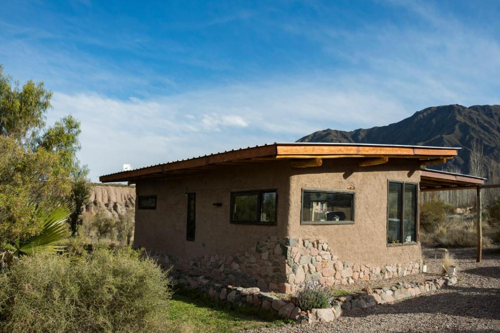 a small stone house with mountains in the background at Casa Nativa in Mendoza