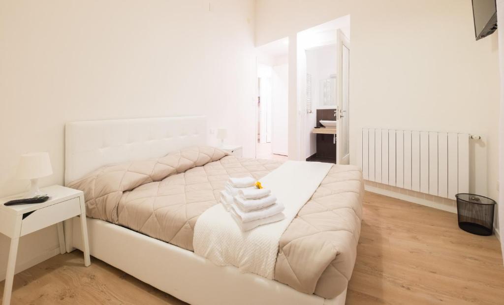 una camera da letto bianca con un letto e asciugamani di Dante 58 a Palermo