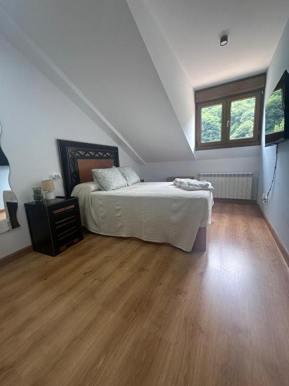 a bedroom with a bed and a wooden floor at El Rincon de Carmen in Felechosa
