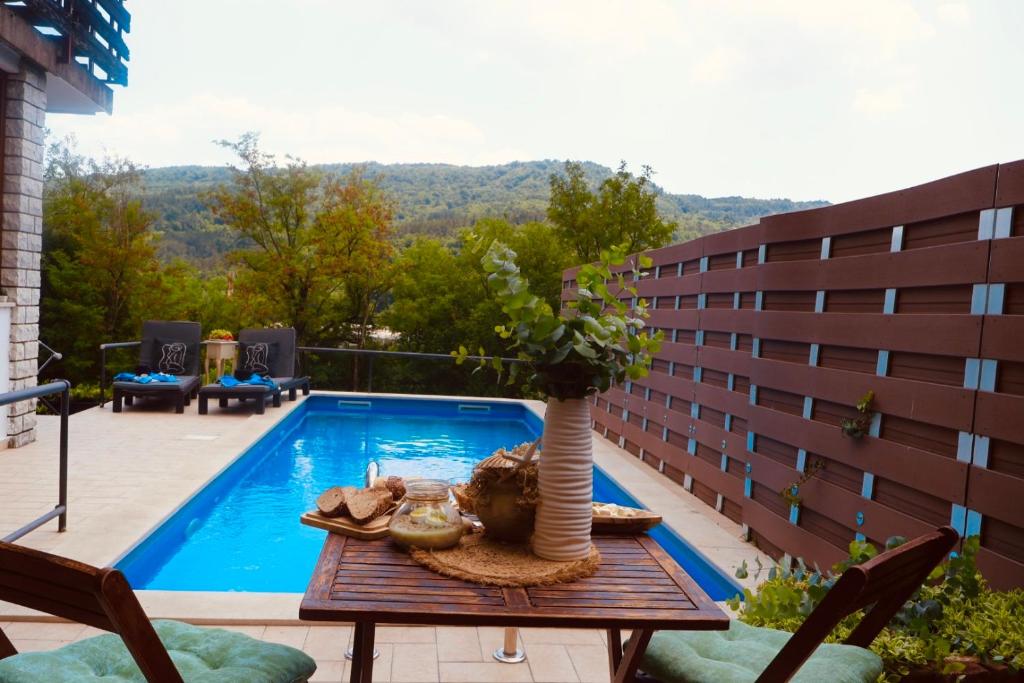 a table with a vase on it next to a swimming pool at Apartman Verona Buzet in Buzet