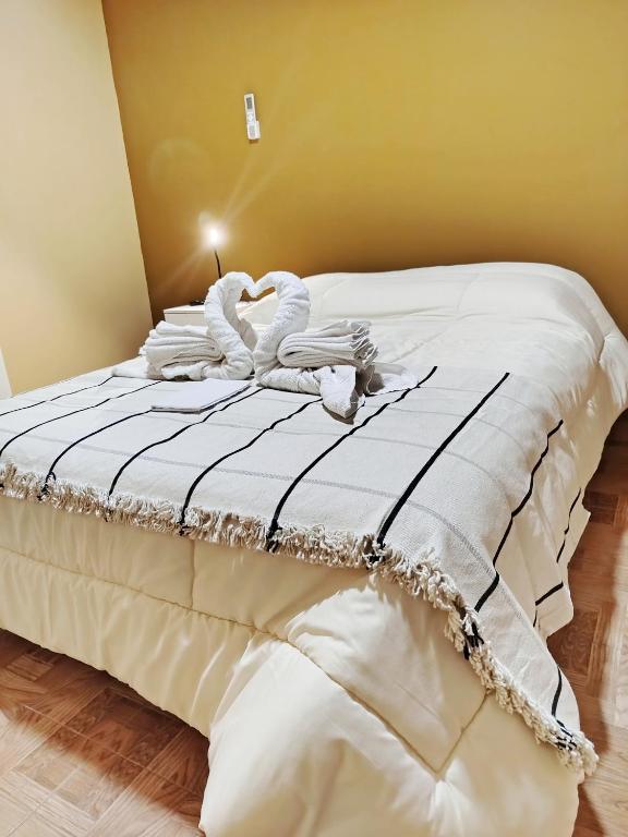 a bed with two white swans laying on it at Alojamiento Las Termas in Fiambalá