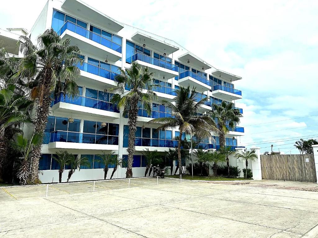 a large building with palm trees in front of it at Punta Centinela - Townhouse 200 in Punta Blanca
