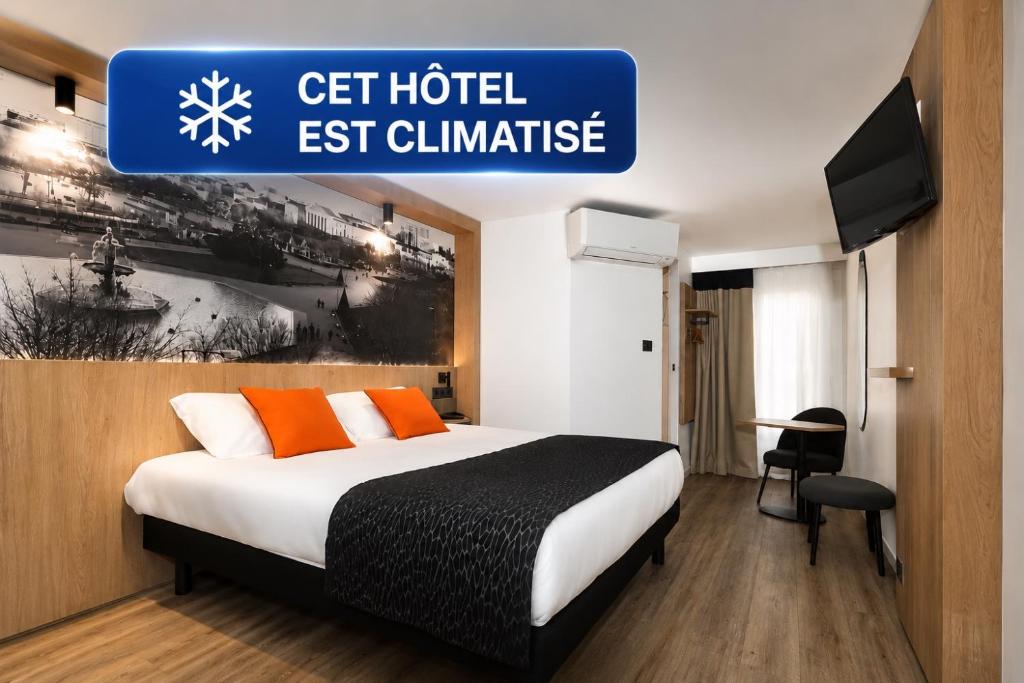 a hotel room with a bed and a sign that reads get hotel est challenge at Logis Hôtel Angers Sud in Angers