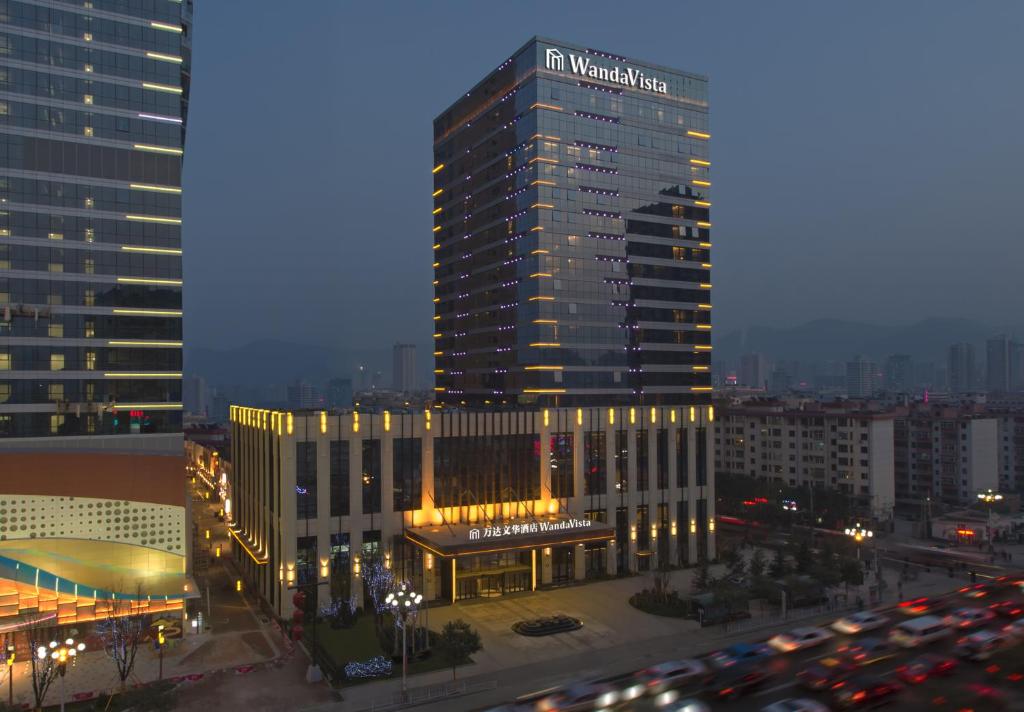 un edificio alto con un cartel en una ciudad en Wanda Vista Lanzhou en Lanzhou