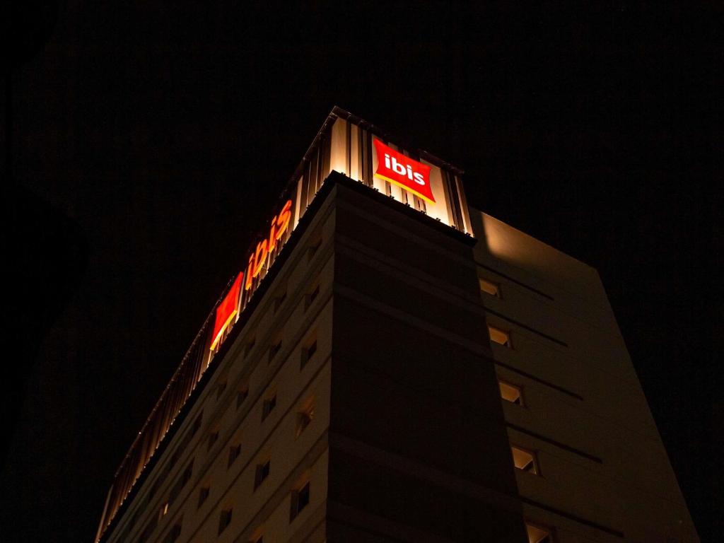 a building with a neon sign on top of it at ibis Jaú in Jaú