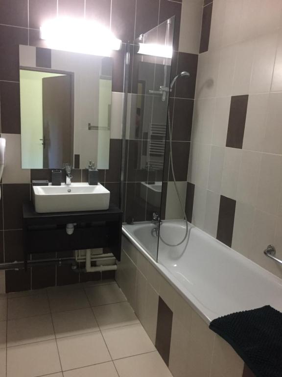 a bathroom with a sink and a tub and a shower at Appartement village 7 in Arles