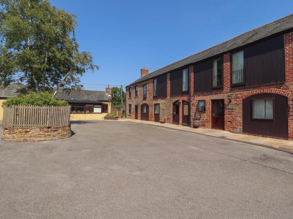 an empty street in front of a brick building at Millers Cottage in Wigton