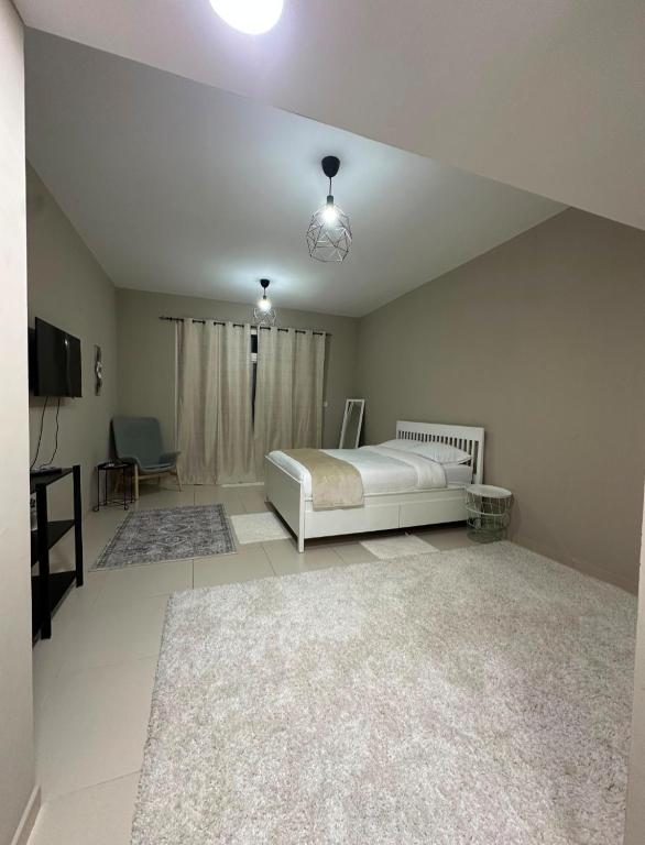 a bedroom with a bed and a television in it at Cosy Studio - Desert Breeze in Ghantoot