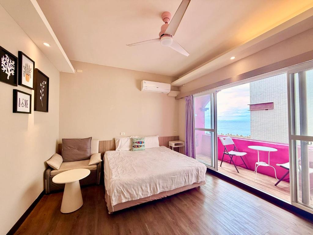 a bedroom with a bed and a balcony at I WoW in Xiaoliuqiu