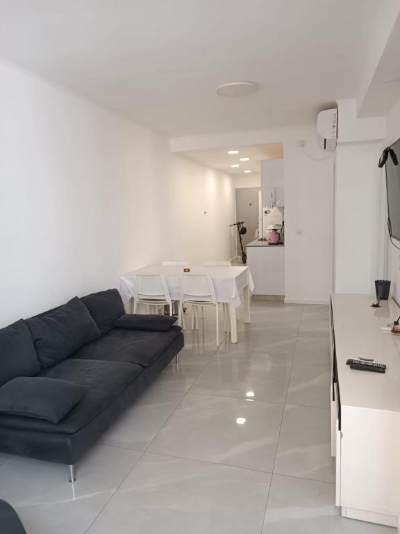a living room with a black couch and a table at Dizengoff 20 in Netanya