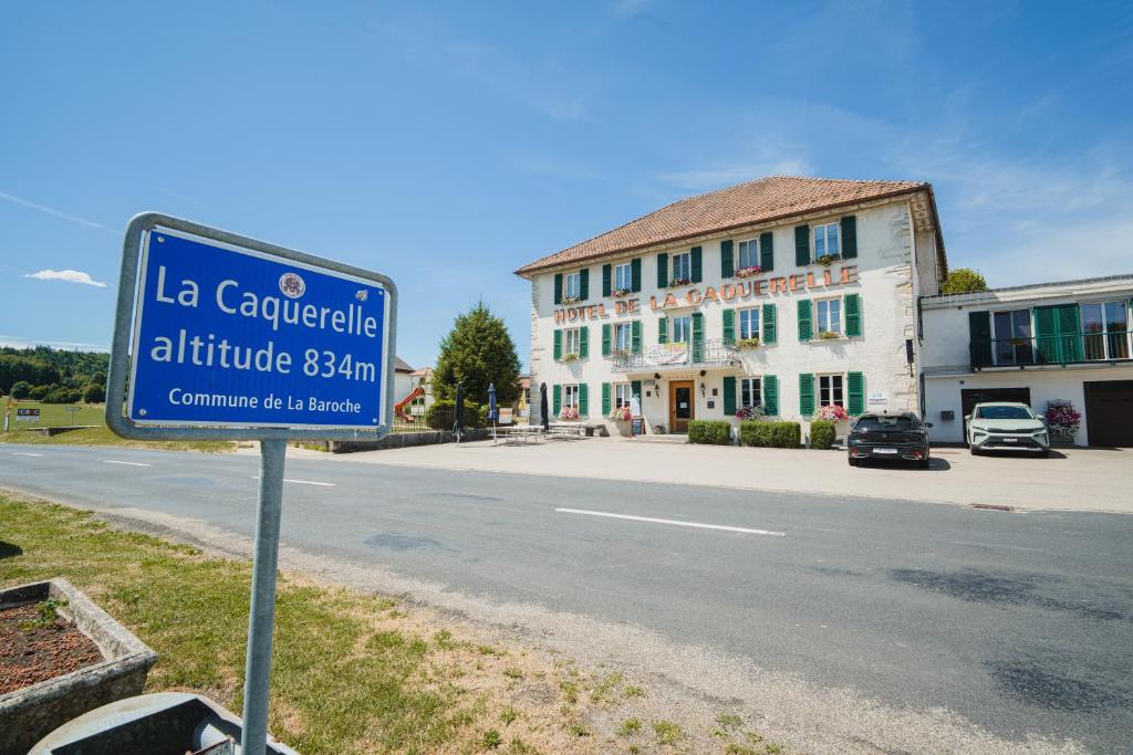 a blue street sign in front of a building at La Caquerelle in Col des Rangiers