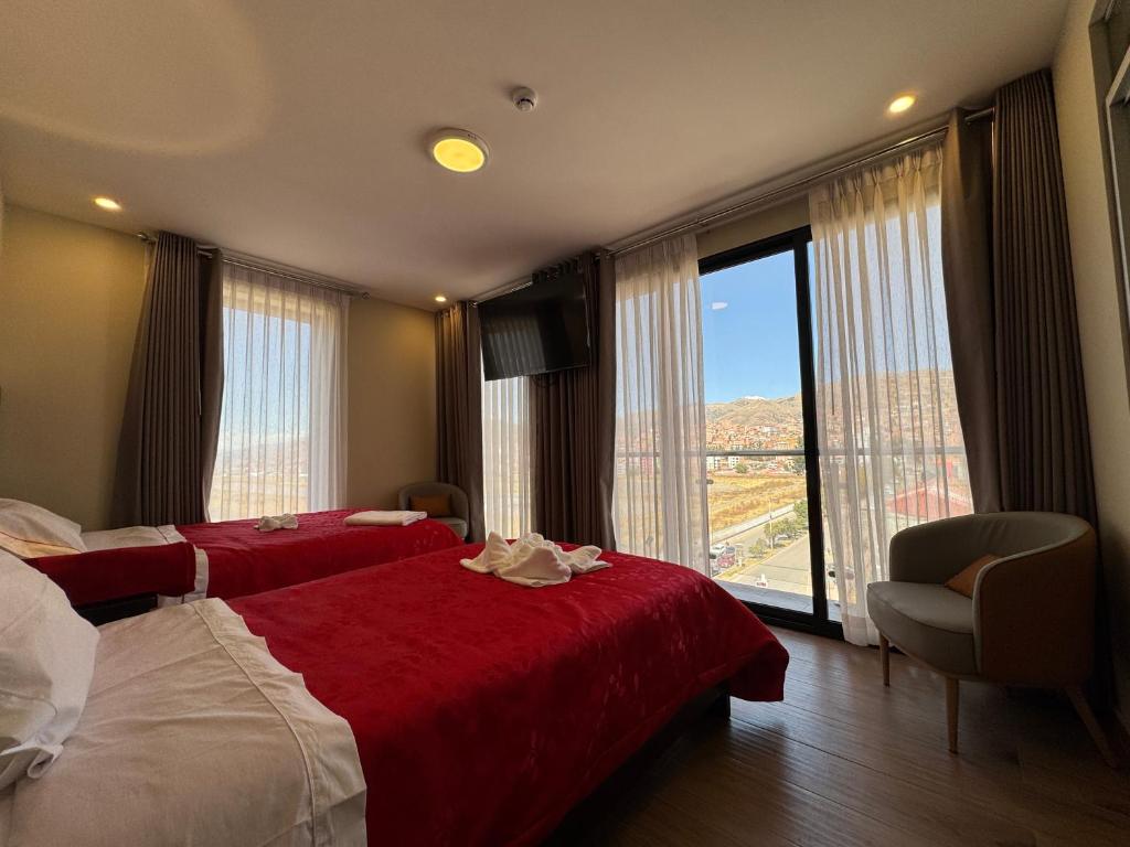 a hotel room with two beds and a large window at Hotel San Miguel Cusco in Cusco