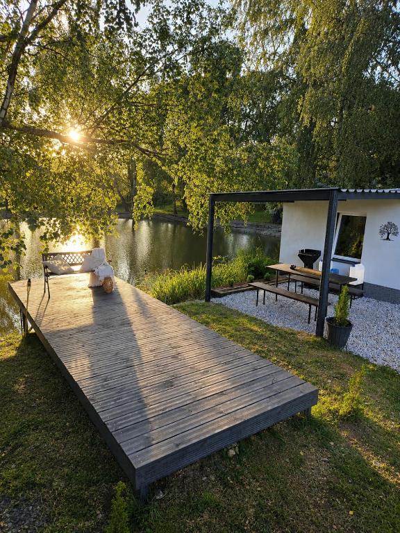 a wooden deck with a bench and a picnic table at Glamping Cesty bez kompasu in Horní Jiřetín