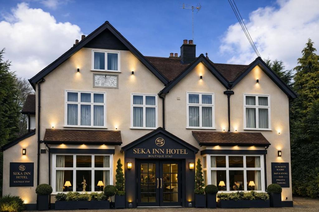 a large white house with the entrance to the maskin inn hotel at Seka Inn Hotel in Crowthorne