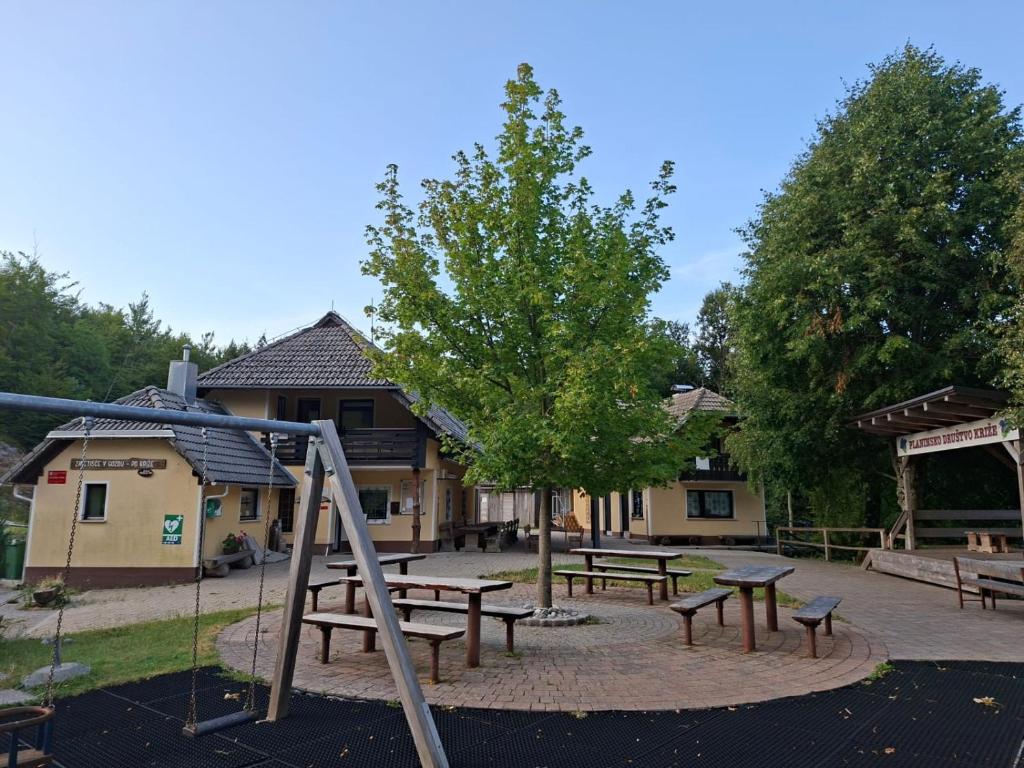 a playground with picnic tables and a swing at Zavetišče v Gozdu in Križe