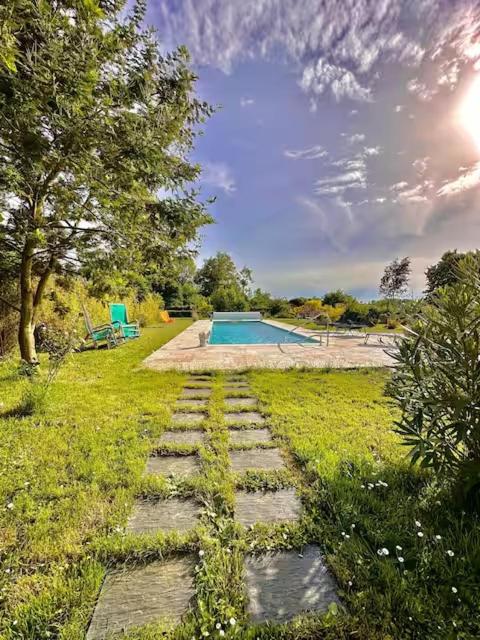 a stone path leading to a swimming pool in a yard at Suite Hortensia in Breuil-Barret