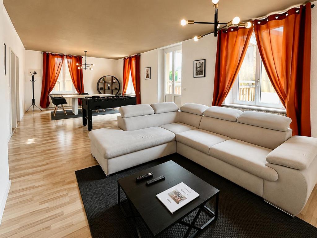 a living room with a couch and a table at vaste appartement rénové avec terrasse in Morteau