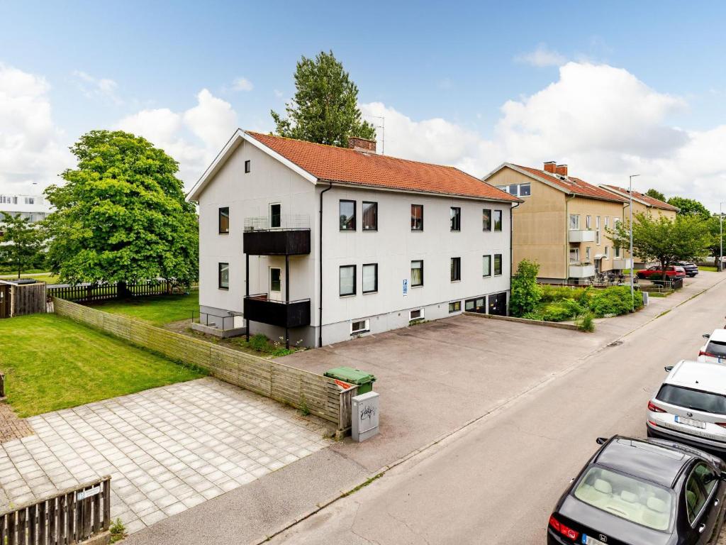 a white house on a street with parked cars at Apartment Odal by Interhome in Halmstad