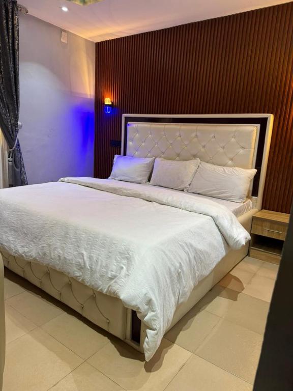 a bedroom with a large bed with white sheets and pillows at Ofee Hotel and Suites in Nsukka
