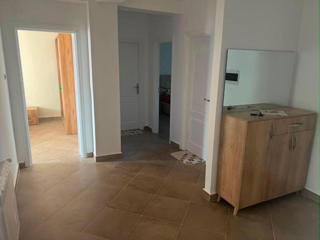 a room with a wooden cabinet and a tiled floor at Aparts 3 F3 BEJAIA VACANCE in Bejaïa
