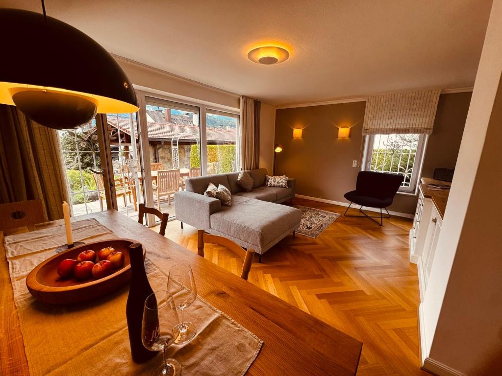 a living room with a table with a bowl of fruit at Alpenzeit - Ferienhaus mit Sauna, Garten und Bergblick bei Garmisch-Partenkirchen in Farchant