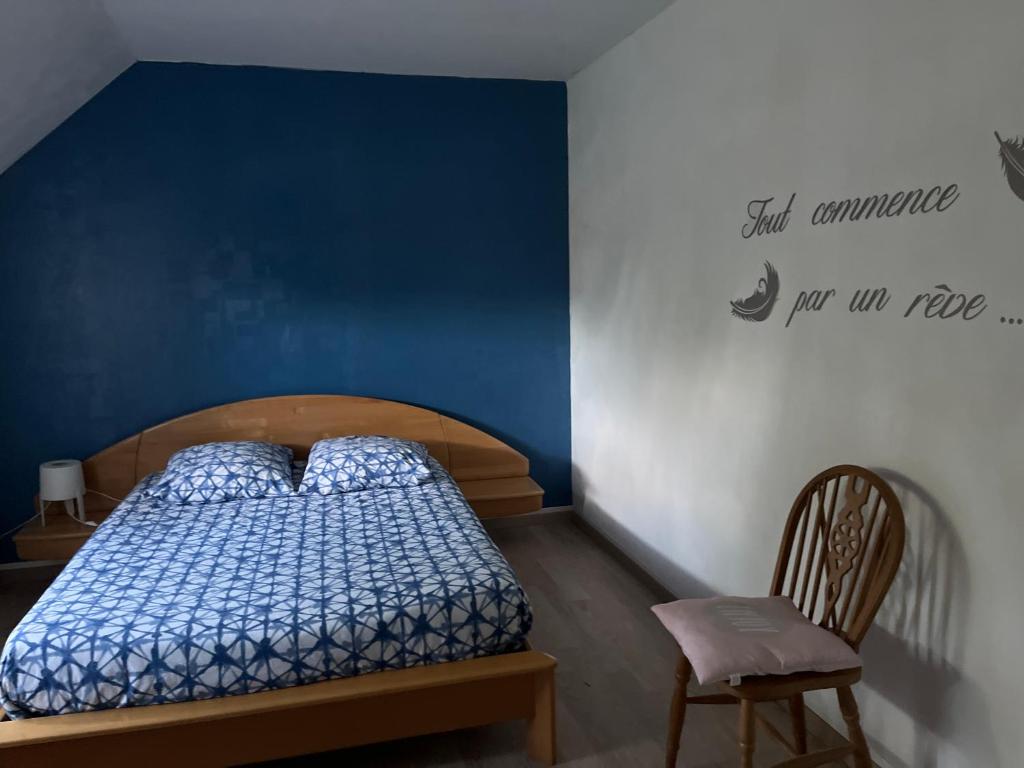 a bedroom with a bed and a blue wall at Les Prunus Clermont -Créans 2 personnes in Clermont-Créans