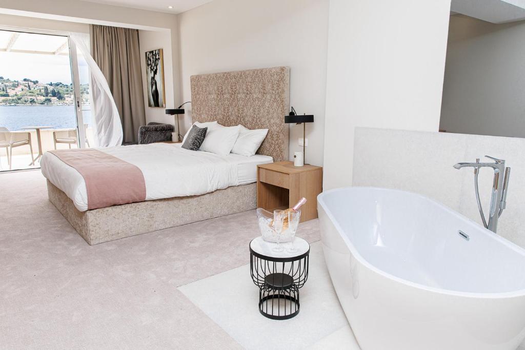 a white bedroom with a tub and a bed at Hotel M in Zaton