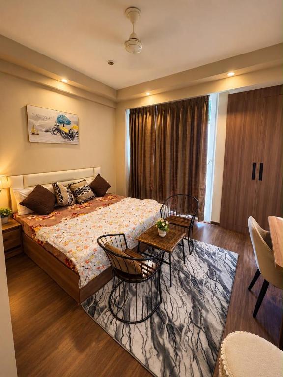a bedroom with a bed and a table and chairs at Royal Stays in Greater Noida