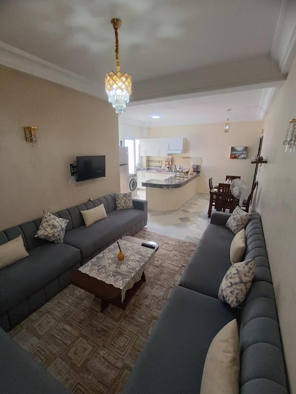 a living room with a blue couch and a table at Dar hicham in Hajreien