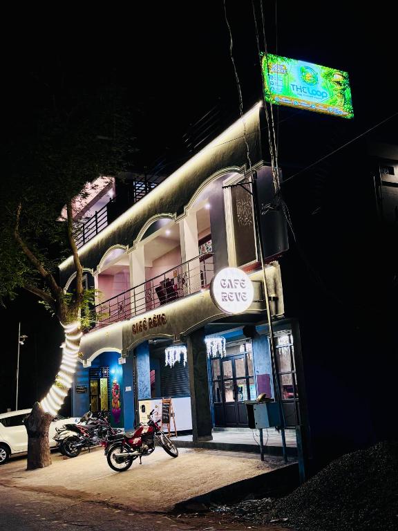 a motorcycle parked in front of a building at night at The Loop - Auroville Main Junction, 5-Minute Drive to Auroville Beach & ECR Road, High-Speed WiFi & Free Parking in Pondicherry